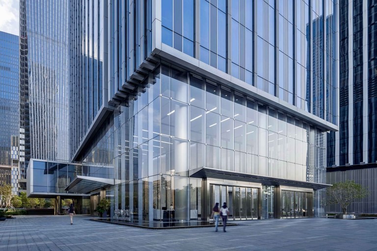 The corner entry, a two-story glazed lobby volume under projecting horizontal fins.